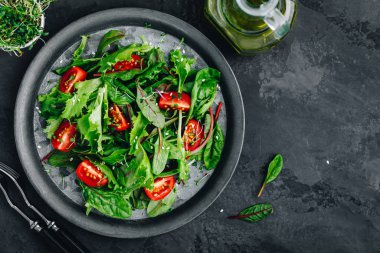 Taze yeşil salata kasesi domates, mikroyeşil ve susam tohumlu.