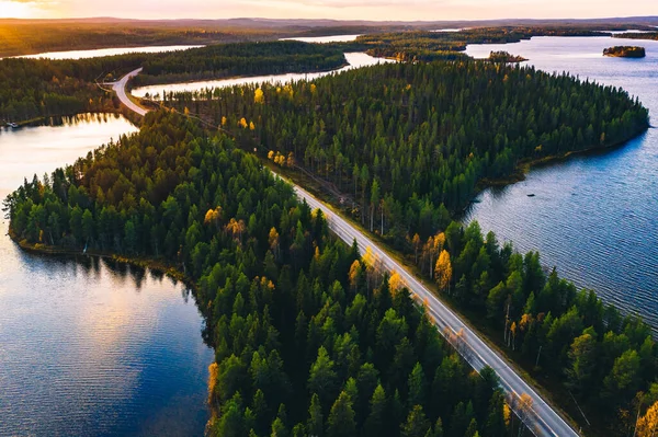 Widok z lotu ptaka na drogę w zielonym lesie letnim z błękitnymi jeziorami o zachodzie słońca w Finlandii — Zdjęcie stockowe