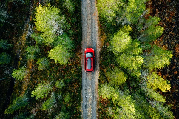 Вид с воздуха на красный автомобиль с багажником на крыше загородной дороги в Финляндии — стоковое фото