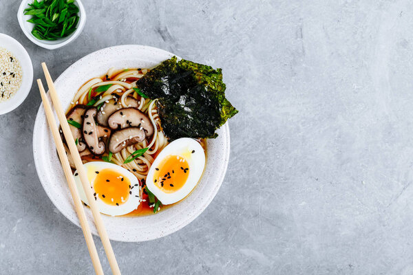 Asian Vegetarian Udon or Ramen noodles soup in bowl with Shiitake mushrooms, boiled eggs and nori sheets