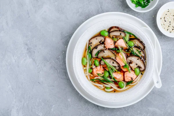 Sopa de macarrão de salmão com cogumelos shiitake, feijão edamame e cebola verde . — Fotografia de Stock