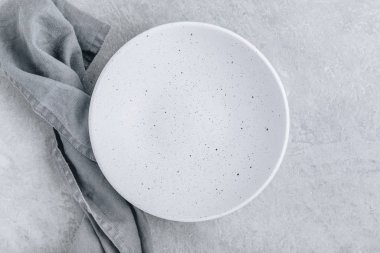 Empty white plate on gray concrete stone background.