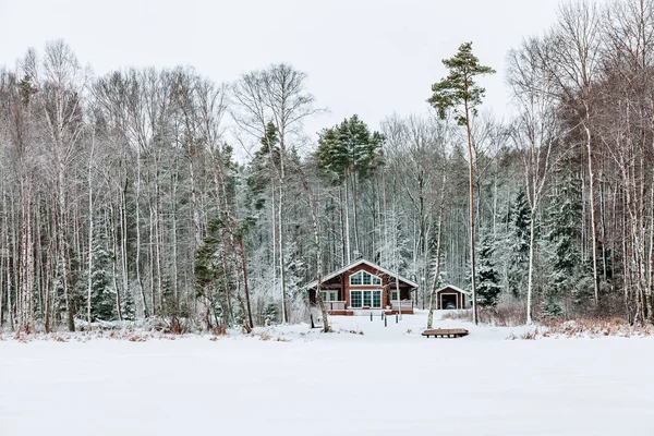 Wooden cottage in snow covered forest in Finland. — Stock Photo, Image