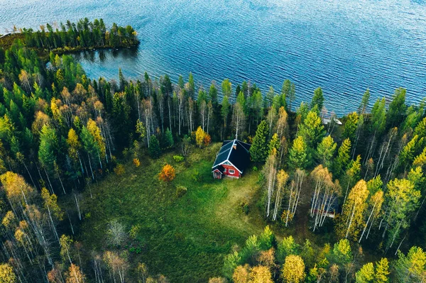 フィンランドの農村部の湖で春の森の中でサウナ付きの赤いログキャビンやコテージの空中トップビュー — ストック写真