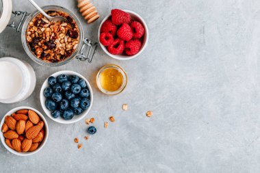 Taze böğürtlenli tahıl gevreği, badem, süt ve bal. Sağlıklı kahvaltı malzemeleri..