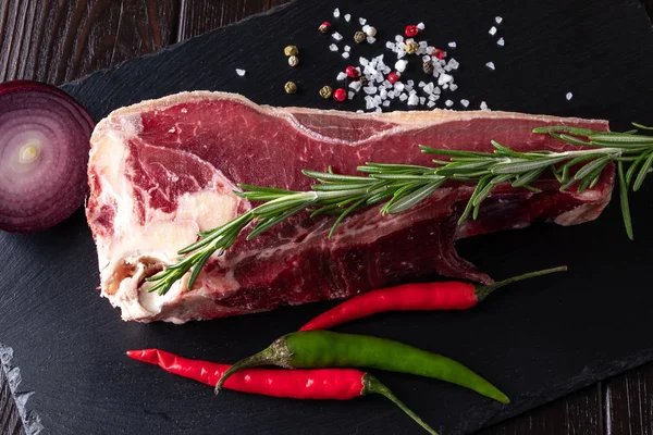 Taze çiğ sığır kaburgası kabaca siyah taştan bir tabakta doğranmıştır..