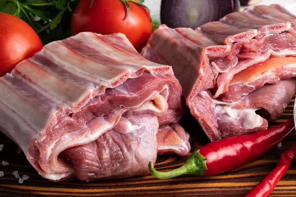 Çiğ et. Baharatlı ve taze sebzeli ahşap kesim tahtasında sığır pirzolası..