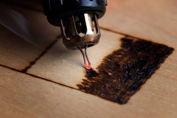 Pyrography. Pirografi kalemiyle odun yakılıyor. Kapat.