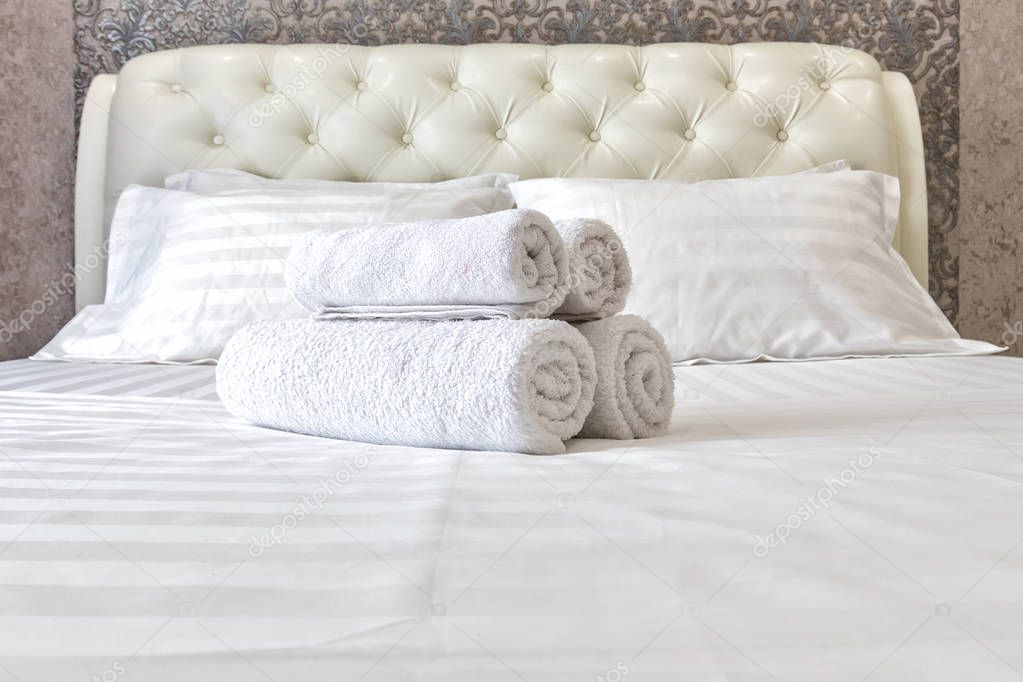 White towels on the bed in the bedroom.