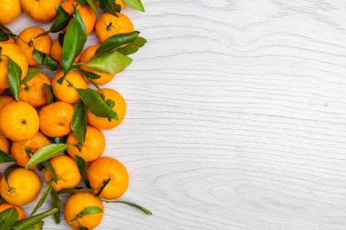 Hafif ahşap arka planda yeşil yapraklı mandalina. Üst Manzara. Kopyalama alanı