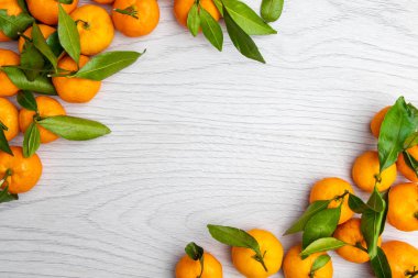 Hafif ahşap arka planda yeşil yapraklı mandalina. Üst Manzara. Kopyalama alanı