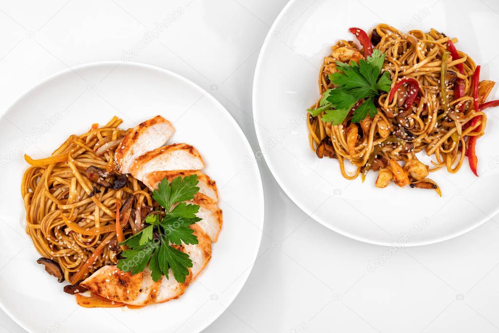 Pan asian food. Wok noodles on a white plate, top view. White background