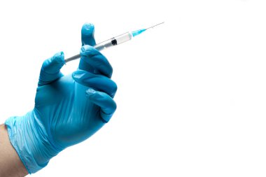 Doktorun elinde mavi bir tıbbi eldiven var. Beyaz arka planda ilaç içeren bir şırınga var. Yakın plan. Metin için yer