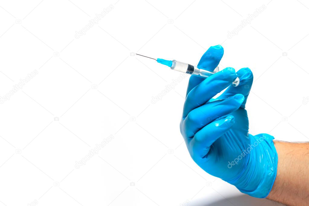 Syringe in a doctor's hand on a white background close-up. Place for text