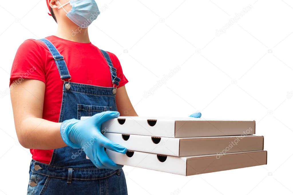 Man from delivery service in red t-shirt, in protective mask and gloves giving food order and holding three pizza boxes isolated over white background