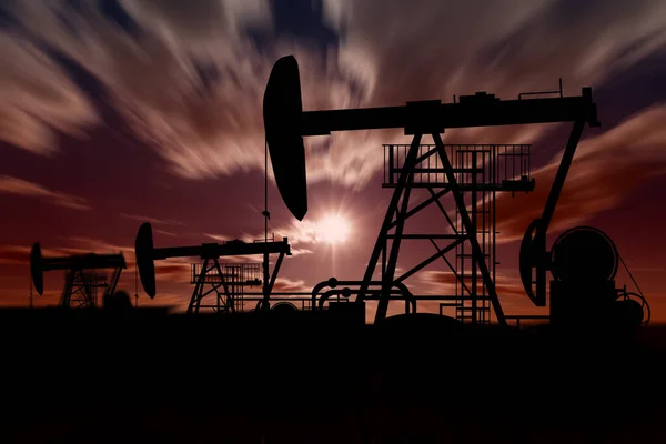 Bulanık gün batımı arkaplanındaki yağ pompaları
