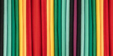 Background from colored cotton clothes. Colors of rainbow. Colored vertical strips of fabric. Banner clipart