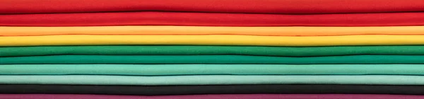 Renkli pamuk giysilerin arka planı. Gökkuşağının renkleri. Renkli yatay kumaş şeritleri. Pankart
