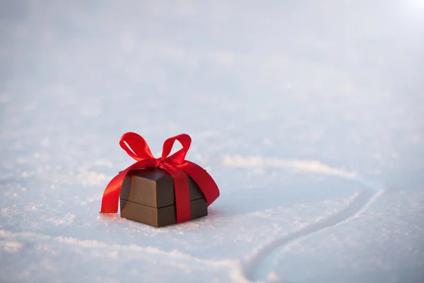 Beautiful romantic gift box on a white snow. — Stock Photo, Image