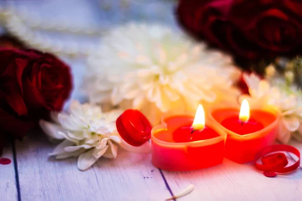 Две красные горящие свечи сердца цветы кланяются близко — стоковое фото