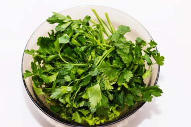 Beyaz arka planda bir kasede taze maydanoz.