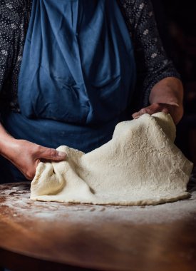 Bir kadın ev mutfağında hamur hazırlıyor..