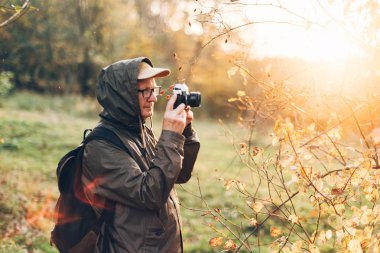 Yaşlı adam ormanda su içiyor..