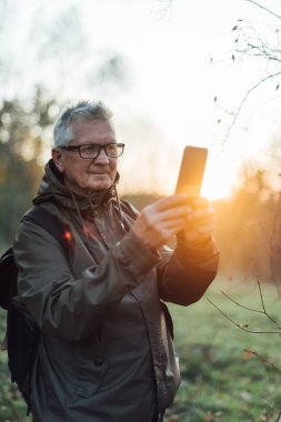 Yaşlı adam gün batımında selfie çekiyor..