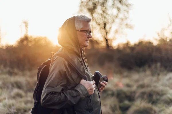 Przystojny Starszy Fotograf Stojący Jesiennym Parku Robiący Zdjęcia Aparatem — Zdjęcie stockowe