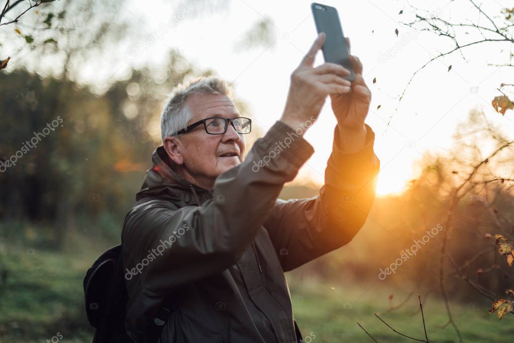 Senior man doing selfie in sunset.