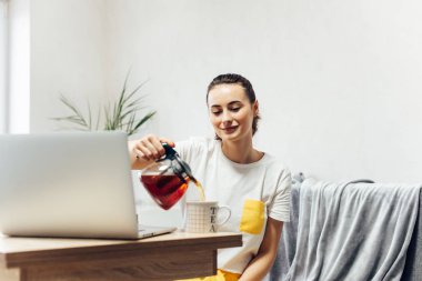 Genç, gülümseyen kadın evde içki dolduruyor..