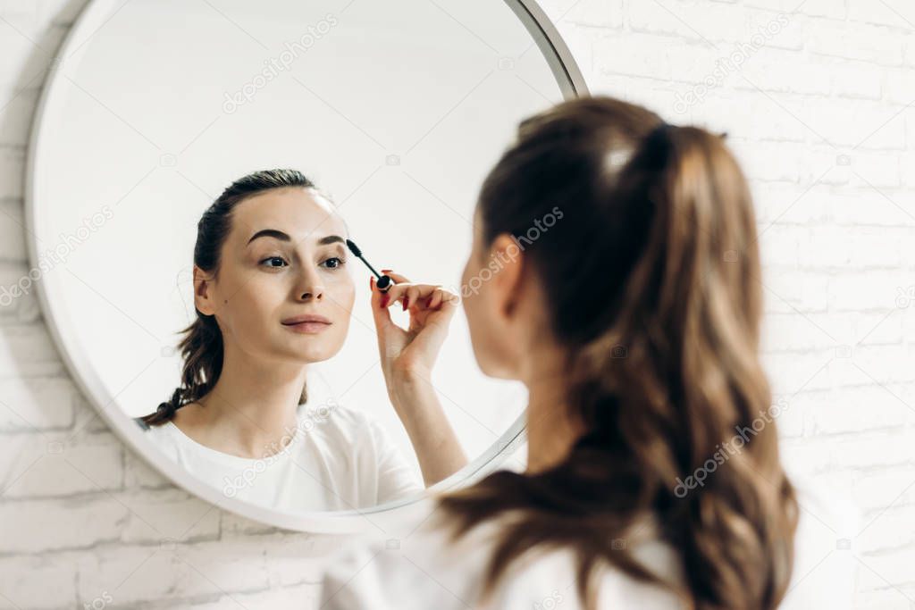 Beauty makeup woman putting mascara eye make up.