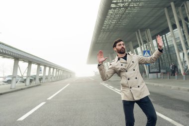 Neşeli ve Mutlu İş Adamı Şehir Beton Duvarı 'nın yanında Aktif Bir Sokakta Dans Ediyor. Gri bir takım elbise giyiyor. Güneşli Gün.