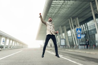 Neşeli ve mutlu iş adamı aktif olarak sokakta dans ediyor. Gri bir takım elbise giyiyor. Güneşli Gün.