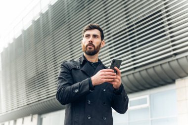 Genç bir işadamı cep telefonuna bakıyor..