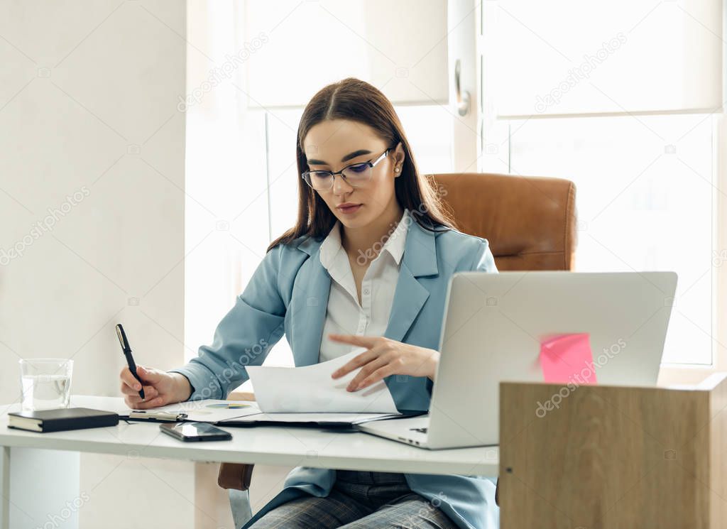 Young focused woman working with chart.