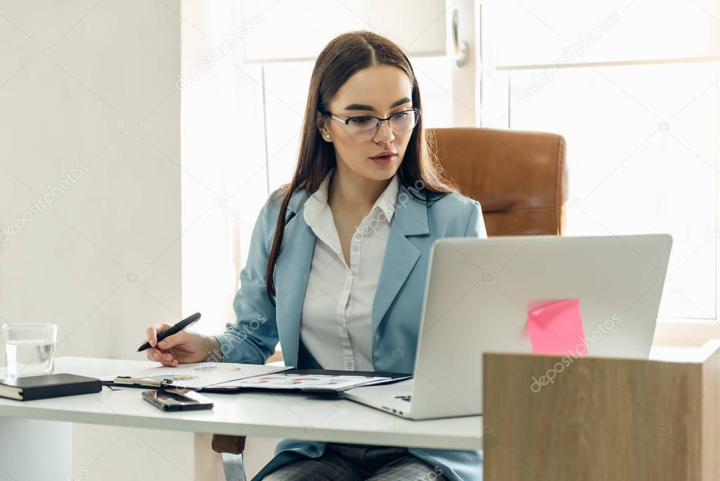 Young focused woman working with chart.