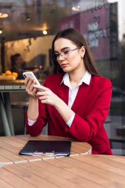 Modern kahve dükkanında cep telefonu kullanan güzel bir iş kadını..