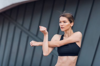 Güneşli bir günde ellerini gökyüzüne doğru uzatan sporcuların düşük açılı görüntüsü.