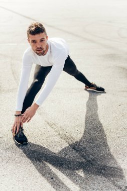 Sporcu koşuda esneme egzersizi yapıyor..
