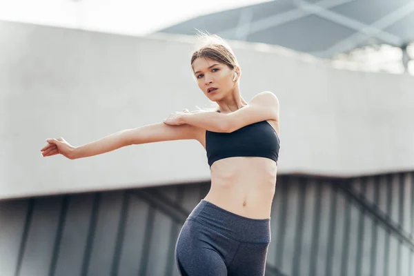 Belle fille de sport de fitness avec corps en forme en vêtements de sport faisant de l'exercice à l'extérieur . — Photo