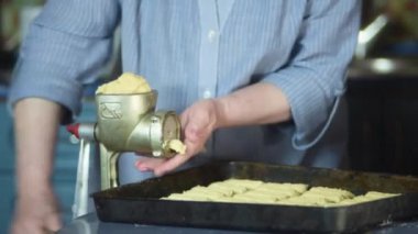 Büyükanne yemek pişiriyor, un hamuru hazırlıyor, büyükanne elleri kapalı. Üst düzey bir kadın kendi mutfağında hamur işi pişiriyor..