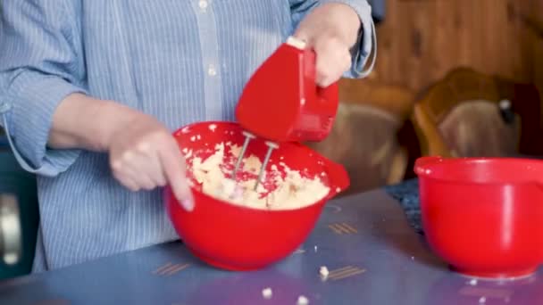 Mixing dough in bowl with motor mixer. Woman preparing a dough. Cooking cake. Close up video of a chef using an electric mixer. Social distancing. — Stock Video