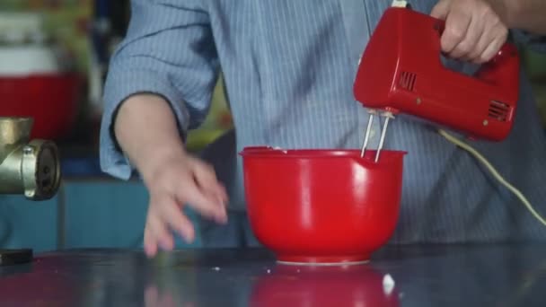 Mixing liquid dough for baking using an electric mixer. Mixing dough in bowl with motor mixer. Woman preparing a dough. Cooking cake. Social distancing. — Stock Video