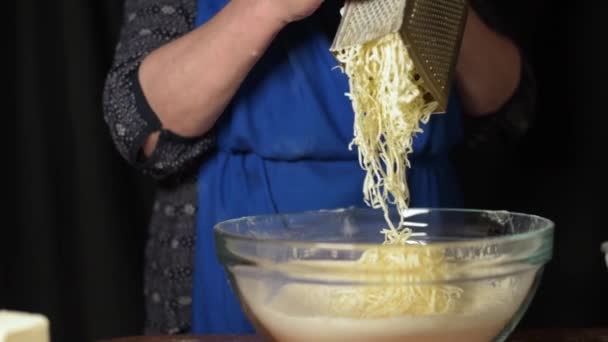 Avó cozinhar esfrega um pedaço de manteiga em um ralador. A margarina é produzida e esmagada. Movimento lento — Vídeo de Stock