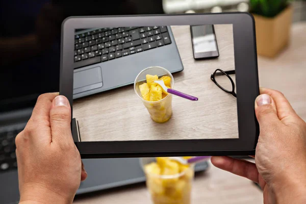 Imagem da caixa de almoço de frutas no escritório usando o tablet digital — Fotografia de Stock