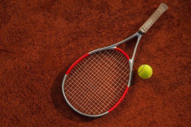 Tenis raketi ve top sahada.