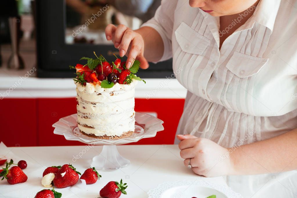 Woman Carefully Icing The Cake