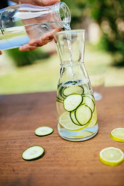 Pouring Water In The Bottle With Cucumber
