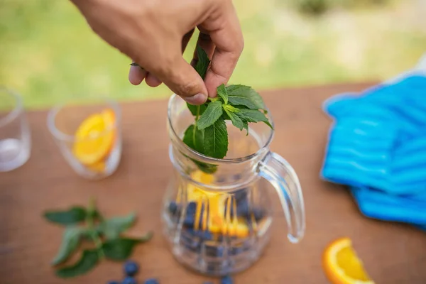 Att placera Mint i glasflaska med blåbär och Orange — Stockfoto